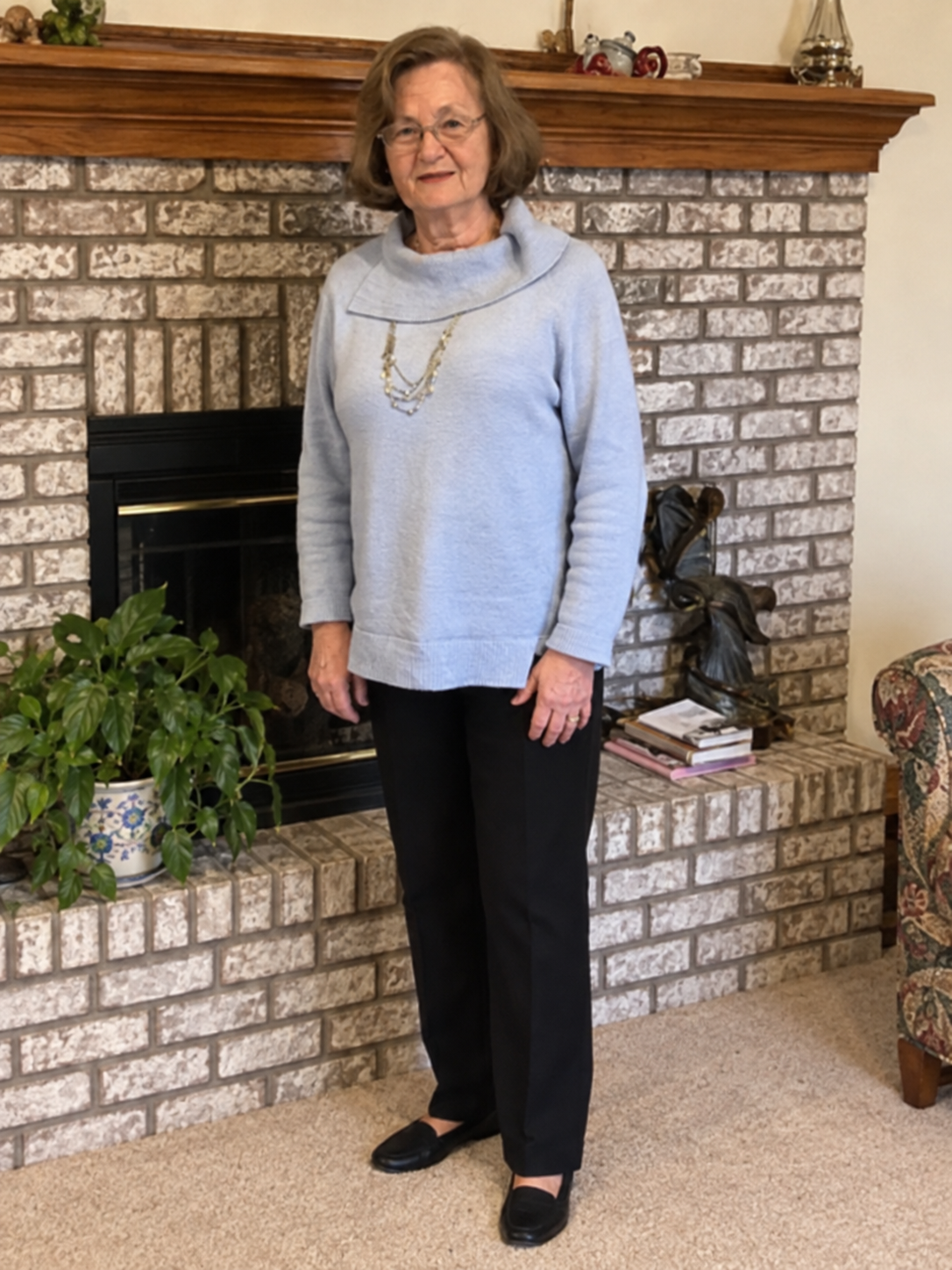 Beverly K. Robertson standing in front of a fireplace